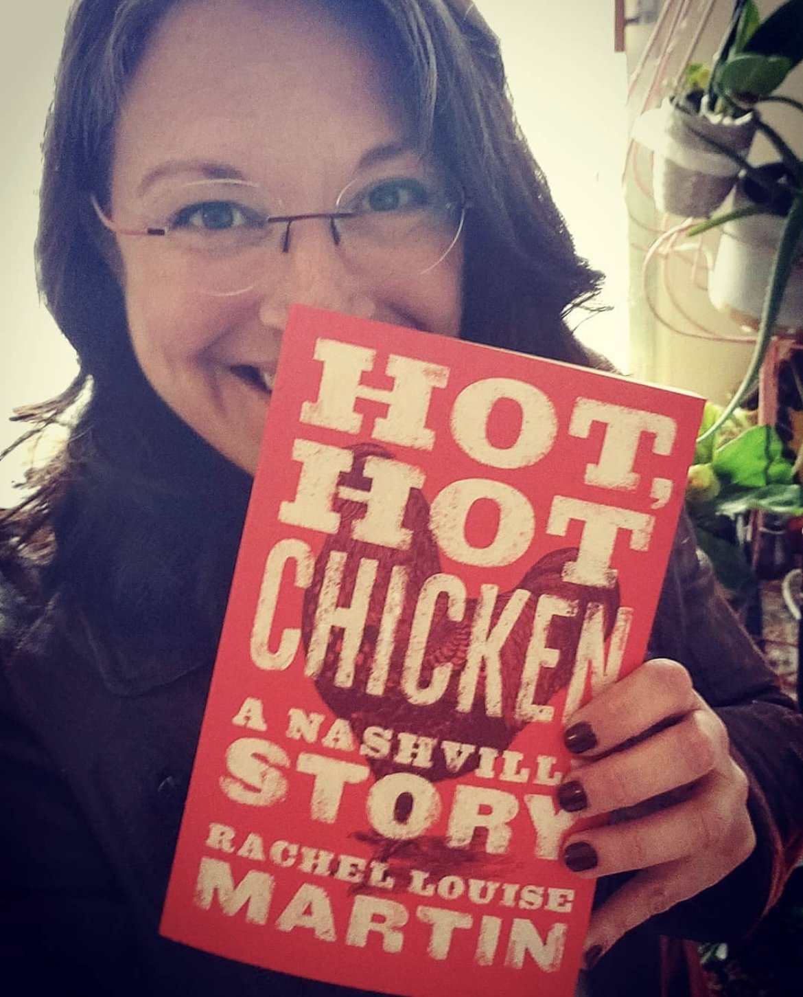 Tour guide Rachel L. Martin holding her book Hot, Hot Chicken